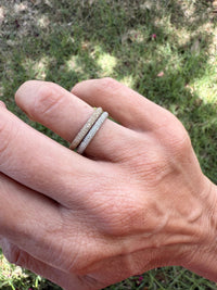 The Karat Concierge pave eternity bands in 18K yellow and white gold with sparkling diamonds on a finger