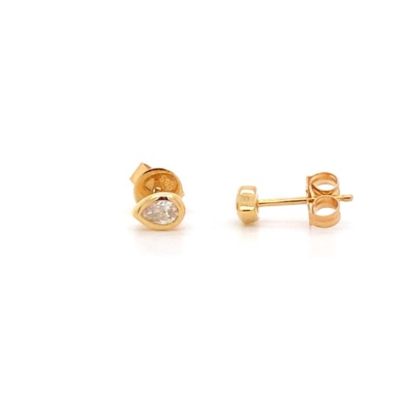 The Karat Concierge pear shaped diamond stud earrings in 14K yellow gold with a dainty bezel setting.