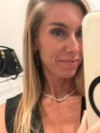 The Karat Concierge Meridian pear-shaped diamond tennis necklace in 14K yellow gold worn by a woman