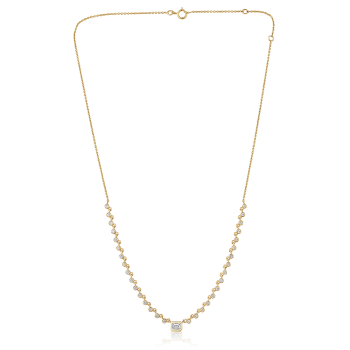 The Karat Concierge Peyton necklace featuring a bezel set emerald cut diamond and round diamonds in 14K yellow gold.