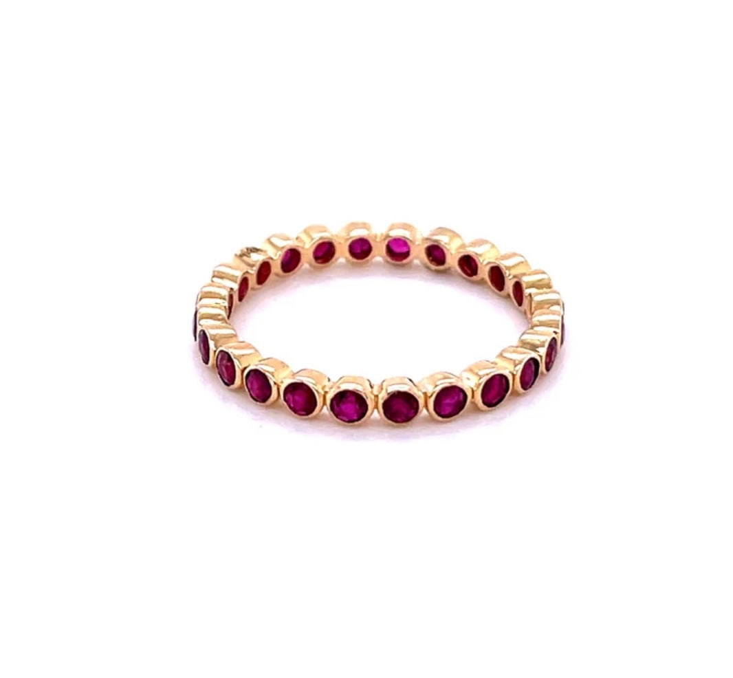 The Karat Concierge 14K yellow gold eternity band featuring a continuous row of bezel-set vibrant red rubies.