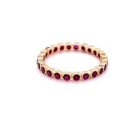 The Karat Concierge 14K yellow gold eternity band featuring a continuous row of bezel-set vibrant red rubies.