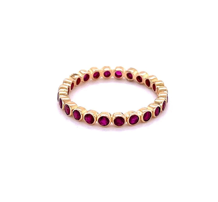 The Karat Concierge 14K yellow gold eternity band featuring a continuous row of bezel-set vibrant red rubies.