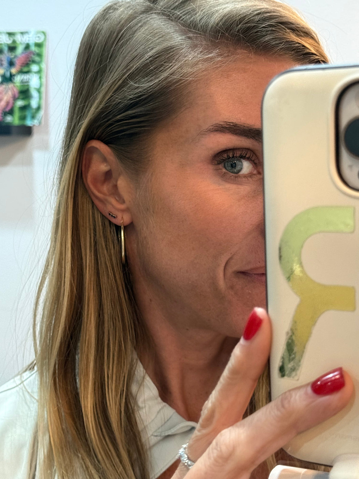The Karat Concierge 14K yellow gold curved bar earrings with three blue sapphires worn on a woman's ear.