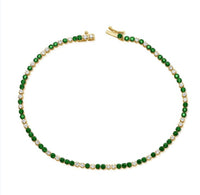 The Karat Concierge tennis bracelet featuring alternating green tsavorite and white diamonds set in 14K yellow gold.
