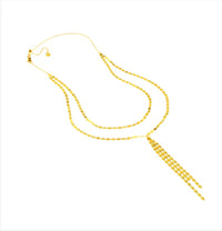 The Karat Concierge Valentino lariat necklace featuring a delicate gold chain with a sliding bolo and tassel drop.