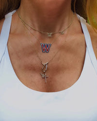 The Karat Concierge Westlake W necklace in gold with red and blue enamel and sparkling diamond accents on a chain.