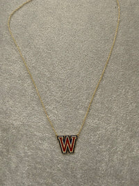 The Karat Concierge Westlake W necklace in yellow gold with red and blue enamel and sparkling diamond accents.