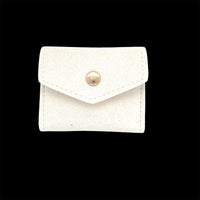 The Karat Concierge white mini travel jewelry case with a gold snap button closure, folded and compact.