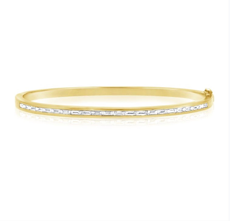 The Karat Concierge yellow gold bangle featuring a channel set row of natural baguette diamonds.