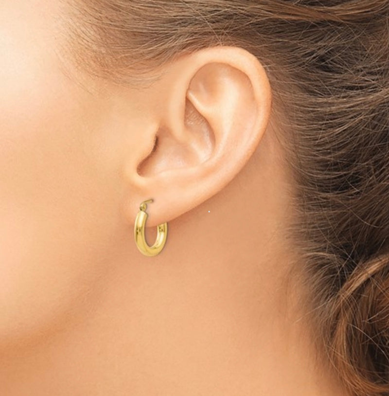 Extra small 14K gold hoop earrings on display 